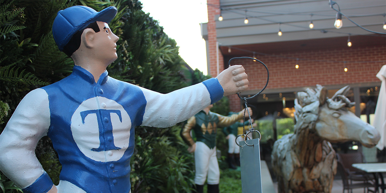 Closeup of a row of horse jockey statues outside Churchill Downs