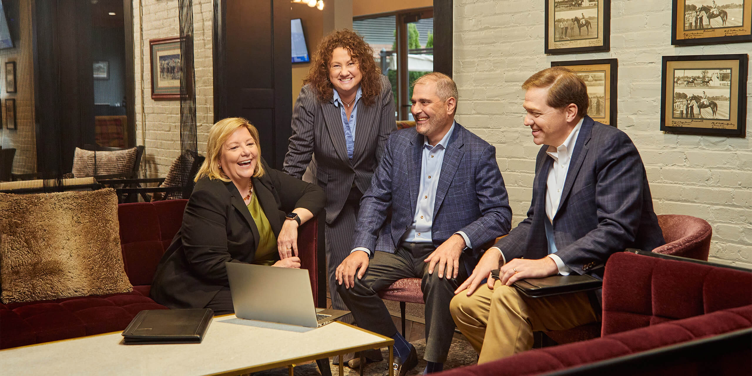 Four associates from the Wealth and Family office team gathered around a table at the Churchill Downs library