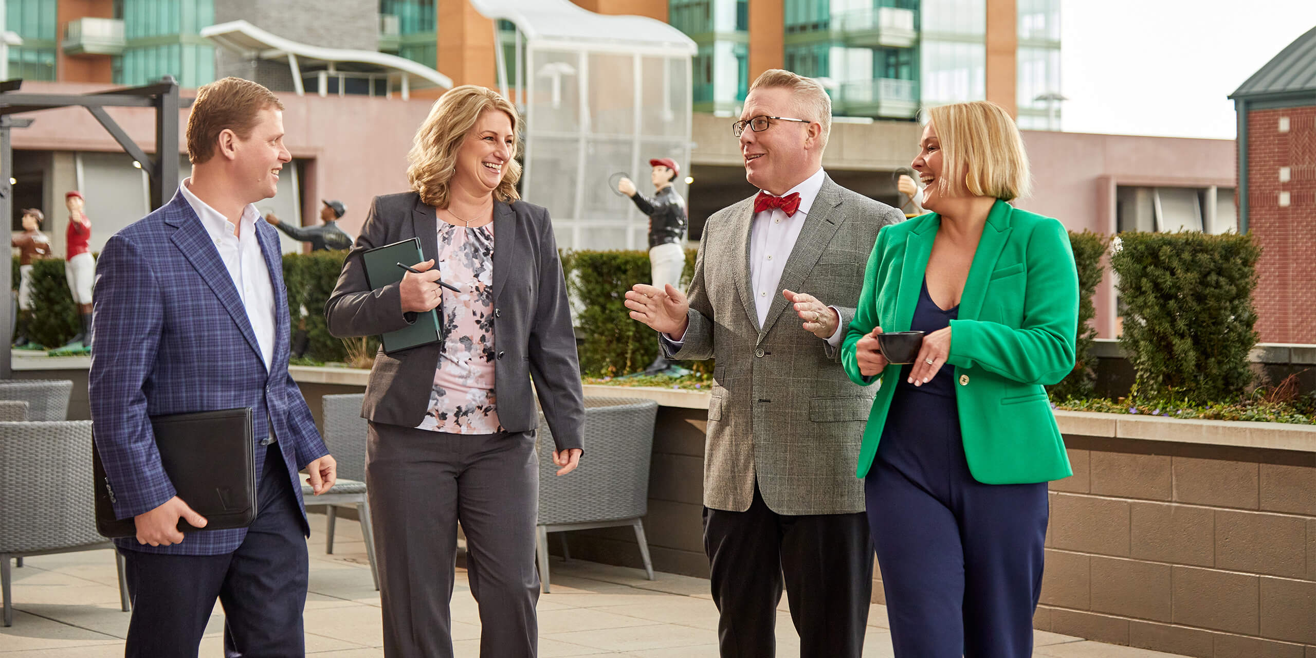 Four associates from the Wealth and Family office team having a discussion in a courtyard